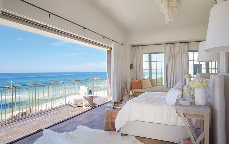Neutral colored bedroom with an open patio onto a beachside deck