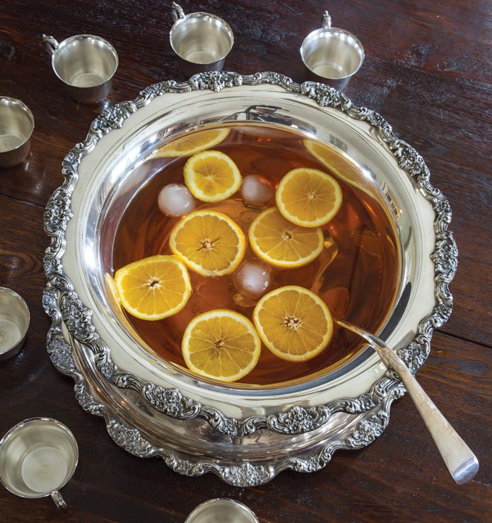 Silver punch bowl filled with punch and citrus